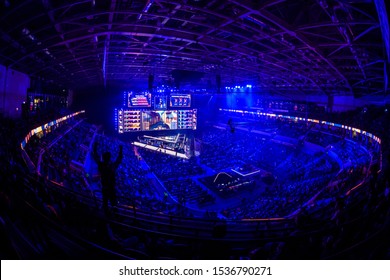 MOSCOW, RUSSIA - 14th SEPTEMBER 2019: esports gaming event. Big illuminated main stage and screen and a fan with a hands raised at arena.