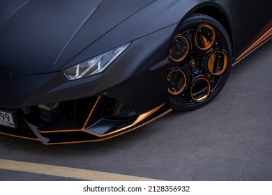 Moscow, Russia 19 February 2022:Part of the wheels and headlights of the Lamborghini Huracan matte color and bronze gold discs