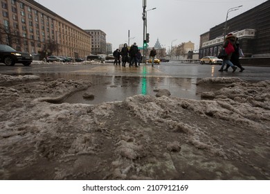 MOSCOW, RUSSIA 23.01.2021 Dirty Grey Black Wet Sloppy Melting Snow, Slush And Ooze, Big Puddle On Asphalt Road. People Crossing Pedestrian Crosswalk. Depressing Winter Thaw. Maykovskaya Square