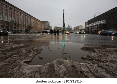 MOSCOW, RUSSIA 23.01.2021 Dirty Grey Black Wet Sloppy Melting Snow, Slush And Ooze, Big Puddle On Asphalt Road And People On Pedestrian Crosswalk. Depressing Winter Thaw. Maykovskaya Square