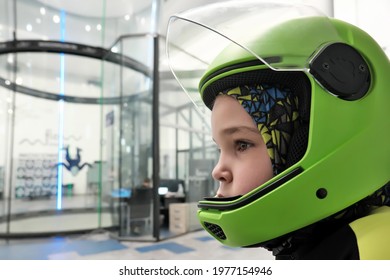 Moscow, Russia - 24th April, 2021: Indoor Recreation. Portrait Of 8-year-old Boy In A Skydiving Helmet In Front Of Wind Tunnel.