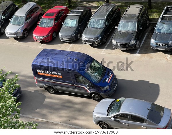 Moscow, Russia - 25 of May 2021: Post delivery\
van parked outside in residential area. Translation in Russian\
means The Post of\
Russia.
