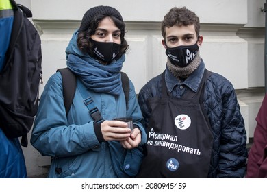 Moscou, Russie - 25 novembre 2021, des centaines de personnes sont venues au tribunal pour liquider l'organisation Human Rights Center MEMORIAL. Un garçon et une fille en masques avec des symboles sur l'arrière-plan du tribunal.