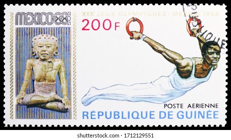 MOSCOW, RUSSIA - APRIL 18, 2020: Postage Stamp Printed In Guinea Shows Gymnast On Rings, Summer Olympics 1968, Mexico Serie, Circa 1969