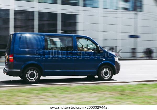 Moscow, Russia - April 2021: Fast moving\
Volkswagen Transporter T5 on the city road. Blue van rides on\
street. Commercial auto in fast motion with blurred background.\
speeding in the city\
concept