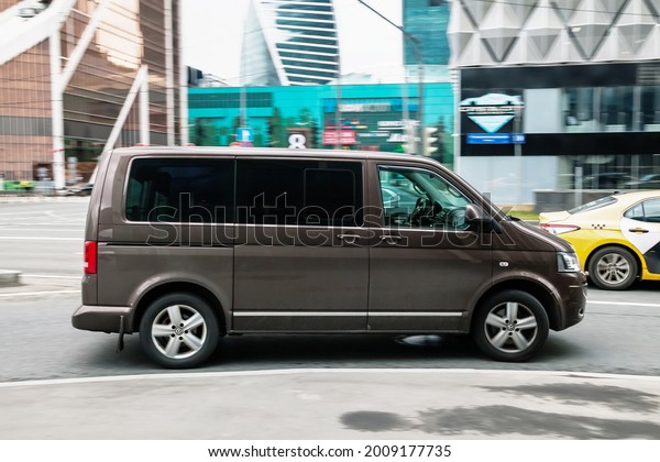Moscow, Russia - April 2021: Fast moving\
Volkswagen Transporter T6 on the city road. Brown van rides on\
street. Commercial auto in fast motion with blurred background.\
Speeding in the city\
concept