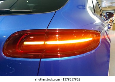 Moscow, Russia - April 22, 2019: Close up of the and taillights of the premium blue Porsche Macan GTS crossover in dealer center. Rear right view