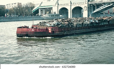 MOSCOW, RUSSIA - APRIL, 29, 2017. Pushed barge full of industrial trash being transported on the river. Modern city pollution problem