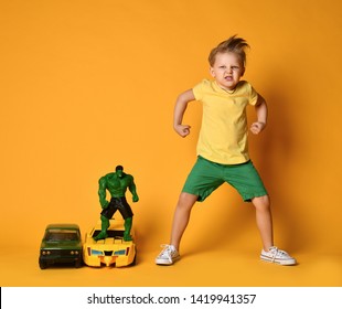 Moscow, Russia - April 3, 2019:Young Boy Kid In Yellow T-shirt And Green Shorts Imitates Favorite Hero Hulk. He Stand In Similar Poses And With The Same Face And Ready To Protect The World 