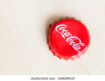 MOSCOW, RUSSIA - APRIL 4, 2019: Used Crown Cork Bottle Cap From Coca-Cola Beverage On Wooden Board With Copyspace. Coca-Cola (Coke) Is Carbonated Soft Drink Manufactured By The Coca-Cola Company