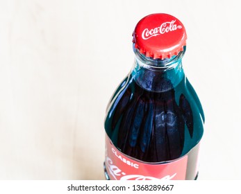 MOSCOW, RUSSIA - APRIL 4, 2019: Above View Of Closed Coca-Cola Glass Bottle On Wooden Table. Coca-Cola (Coke) Is Carbonated Soft Drink Manufactured By The Coca-Cola Company