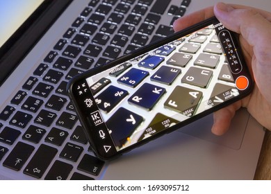 Moscow / Russia - April 4, 2020: IPhone 11 Pro In Hand On A Macbook Keyboard Background. On-screen Video Recording Program