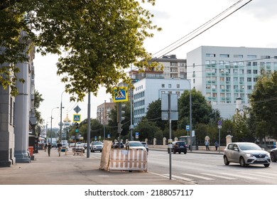 Moscow, Russia - August, 01, 2022. View of road in city center with transport. Road signs, pedestrian crossing, bus stop. Against background of dome of Novodevichy Monastery and hospital.