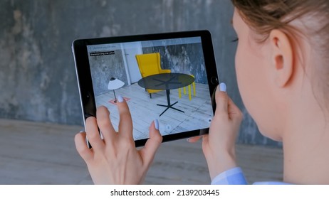 MOSCOW, RUSSIA - AUGUST 1, 2019. Woman using black digital tablet device with augmented reality app and placing virtual furniture in living room - close up. Future, interior, AR, technology concept