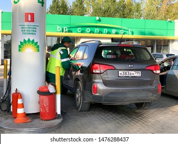 MOSCOW, RUSSIA - August 11, 2019: Gas station worker is pumping gas in KIA at the BP connect gas station in Moscow during the day in summer. 