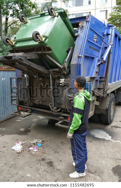 MOSCOW, RUSSIA - August 16, 2016: Work janitors\
change the filled garbage container in the trash dump. Loading a\
garbage truck in\
Moscow.