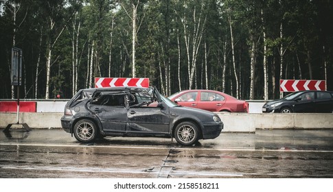 Moscow, Russia - August 18, 2012: Black Hatchback Car Totally Crashed After Shunt With A Truck Due To Drifting On Wet And Narrowed Road, Stands On Roadside