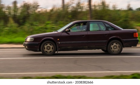 Moscow, Russia - August 2021: Audi 100 (C4) In Motion On The Country Road. Purple Car With Old Man Driver, Driving Fast On The Rural Way, Side View