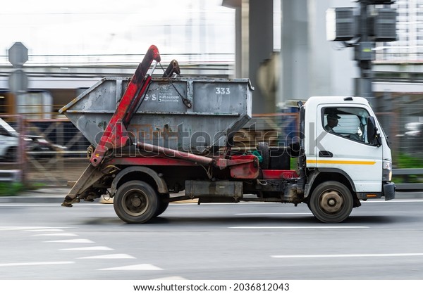 Moscow, Russia\
- August 2021: garbage truck is running on the street in city.\
Recycling truck rides on the road. Collection and transportation of\
waste or garbage\
concept
