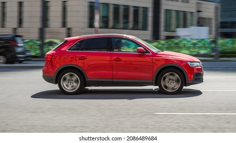 Moscow, Russia - August 2021: Red Audi Q3 Is Driving Down The Street. Side View Of Fast Moving SUV Car On The City Highway