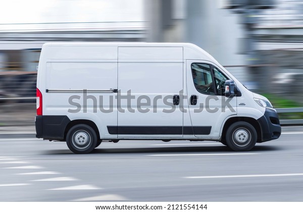 Moscow, Russia - August 2021: White Fiat Ducato\
cargo van with tall roof is driving on the street, side view. Light\
commercial vehicle in\
motion