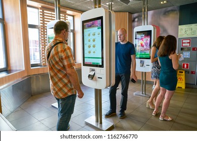 MOSCOW, RUSSIA - CIRCA AUGUST, 2018: Men Use Self Ordering Kiosk In McDonald's