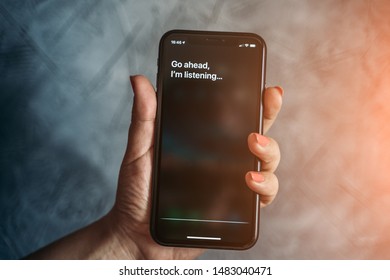 Moscow, Russia - Circa August 2019 : Iphone XR In Female Hand And Activated By Voice Apple Digital Assistant Siri And Text On Smartphone Screen: Go Ahead, I'm Listening...