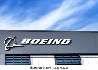 MOSCOW, RUSSIA - CIRCA OCTOBER, 2019: Boeing company sign and lettering on facade of office building against blue clouds sky background closeup view of sign with earth and airplane symbol