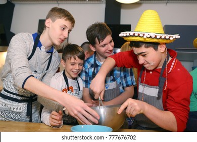 Moscow, Russia, December 16, 2017: Unidentified teenager boys cooking profiterols  on culinary master class lesson  party signifying final days of stydiyng period in Moscow, Russia, December 16,2017
