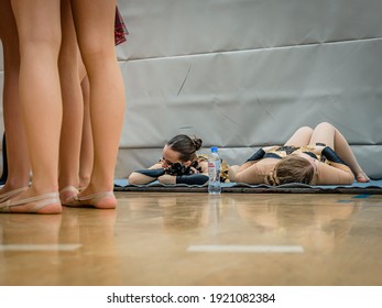 Moscow, Russia - December 22, 2019: Tired, Worn Out Sportswomens Are Resting Lying On Floor After Performing At Cheerleading Championship. Behind The Scenes Of Competition. Cheerleading Is Tough Sport