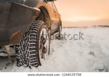 Moscow, Russia - December 25, 2018: The wheel is buried in the snow. The off-road car goes on a winter field.
