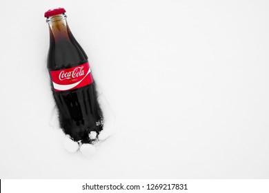 Moscow , Russia - December 28, 2018: Original Glass Bottle Of Coca-Cola Frozen Stuck In The Snow. Top View. Coca Cola Brand . Anno, Since  1886