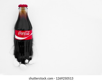 Moscow , Russia - December 28, 2018: Original Glass Bottle Of Coca-Cola Frozen Stuck In The Snow. Top View. Coca Cola Brand . Anno, Since  1886