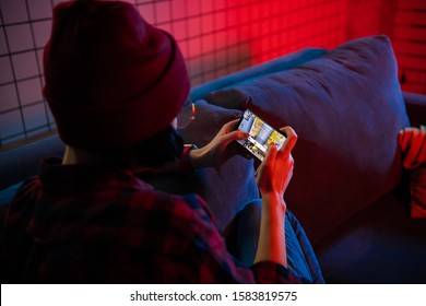 MOSCOW, RUSSIA - December 6, 2019: Girl playing PUBG FPS game on smartphone. Teenager into mobile gaming