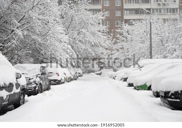 Moscow, Russia - Feb 04.2018. Cars in yard of\
house during heavy\
snowfall