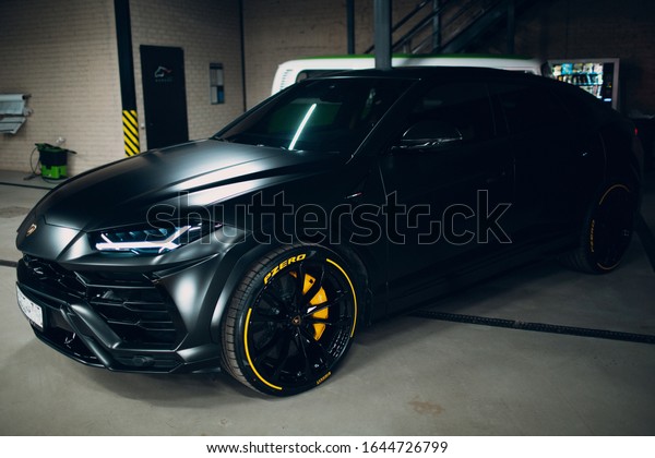 Moscow Russia - February 10, 2019: Lamborghini\
Urus black sport car with yellow wheels. Sports cars tint black\
Pirelli tires,