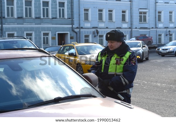 MOSCOW, RUSSIA - FEBRUARY 15, 2017:An inspector\
of the road patrol service of the police talks with the driver of a\
stopped car in the center of\
Moscow