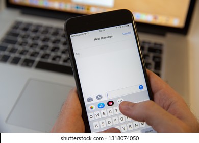 Moscow / Russia - February 20, 2019: Typing A New Message On The IPhone On The Background Of The MacBook