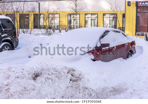 Moscow. Russia. February 2020. Snowfall in
February. Car in a snowdrift. After a heavy snowfall, the car was
covered with snow from all sides. To leave you will have to work
with a shovel