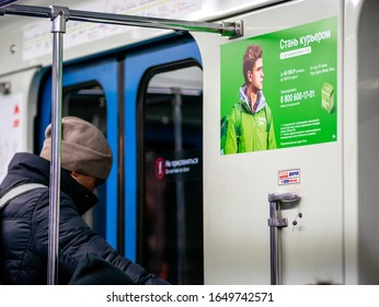 Moscow, Russia - February 8, 2020: A Man Rides In A Subway Car Next To An Delivery Club Advertisement. A Young Man Stands At Door Of Subway Train. Poster Invites To Work As Couriers For Food Delivery