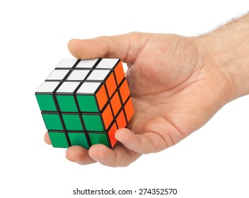 MOSCOW, RUSSIA - January 07, 2015: Hand And Rubik's Cube Puzzle Isolated On The White Background. Cube Was Invented By A Hungarian Architect Erno Rubik In 1974.