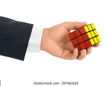 MOSCOW, RUSSIA - January 07, 2015: Hand And Rubik's Cube Puzzle Isolated On The White Background. Cube Was Invented By A Hungarian Architect Erno Rubik In 1974.