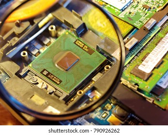 Moscow, Russia - January 10, 2018: Intel Chip On The Laptop Motherboard Under Magnifying Glass, Vulnerabilities Meltdown And Specter Theme         