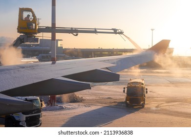 Moscow, Russia - January 12, 2022: Sheremetyevo International Airport. De-icing an aircraft wing. Process of spraying anti-icing white fluid the rear part of the wing of a plane at the airport