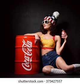 MOSCOW, RUSSIA - JANUARY 13, 2016: Beautiful Woman Drinking Coca Cola Bottle Can 33 Cl. Coca-Cola Is The Most Famous Brand Soft Drink In The World On Black Background