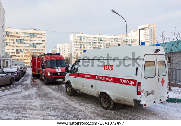 MOSCOW, RUSSIA - JANUARY 23, 2020: A fire engine\
and ambulance arrived at the scene in the courtyard of a\
residential building in a residential area, winter view near the\
entrance  in Moscow