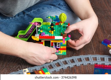 MOSCOW, RUSSIA - January 4, 2016: Man Hands Playing With Town Built Of Lego With Model Release