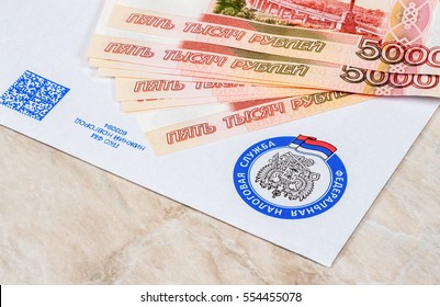 MOSCOW, RUSSIA - JANUARY 9, 2017: Tax Payment Notice Letter With Logo Of The Federal Tax Service Of Russia And Ruble Banknotes Above. Tax Payment Concept