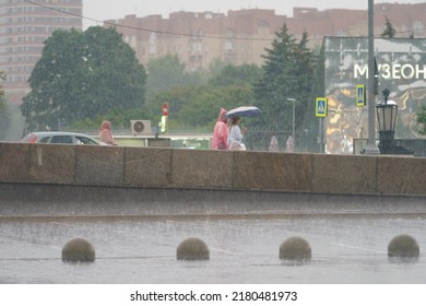 Moscow, Russia - July 10, 2022: Raining Day In City Center At Summer. Wet People Under Umbrella. Texture Of Strong, Fresh And Powerful Water Drops And Sprays. Tropical Storm