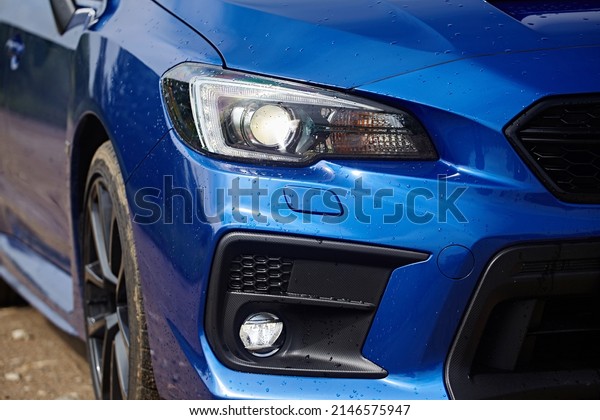 Moscow, Russia - July 2018: A fragment of the front of a\
modern blue car with headlights, bumper, wheel, fog lamp close-up\
